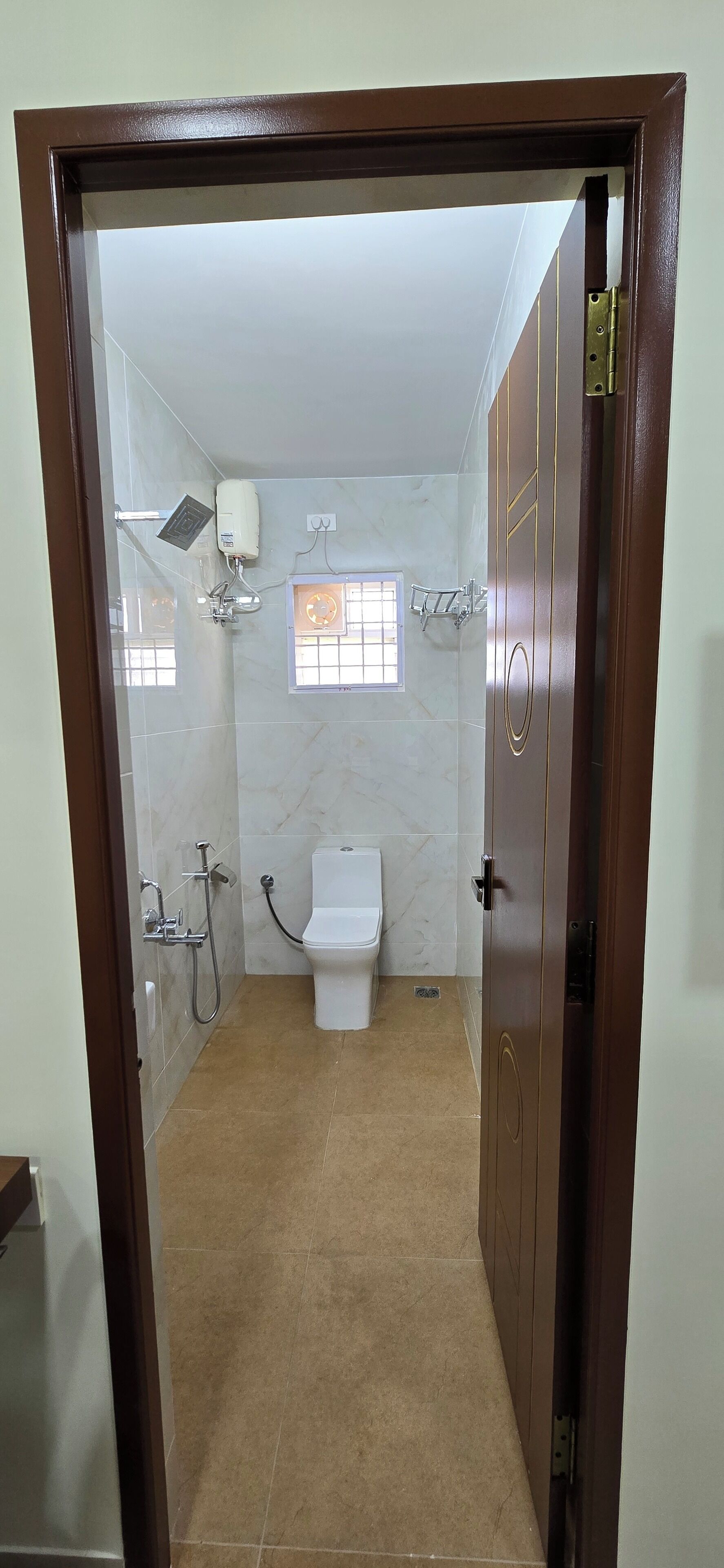Une salle de bain avec des toilettes, une douche et une fenêtre.