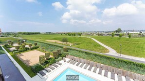 A pool area with lounge chairs and a sign for RENTUS holiday homes. - Seange - with beautiful view and many facilities (Nieuwpoort)