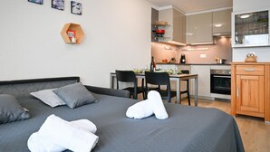 Une chambre d’hôtel moderne équipée d’un lit, d’un bureau et d’une kitchenette.