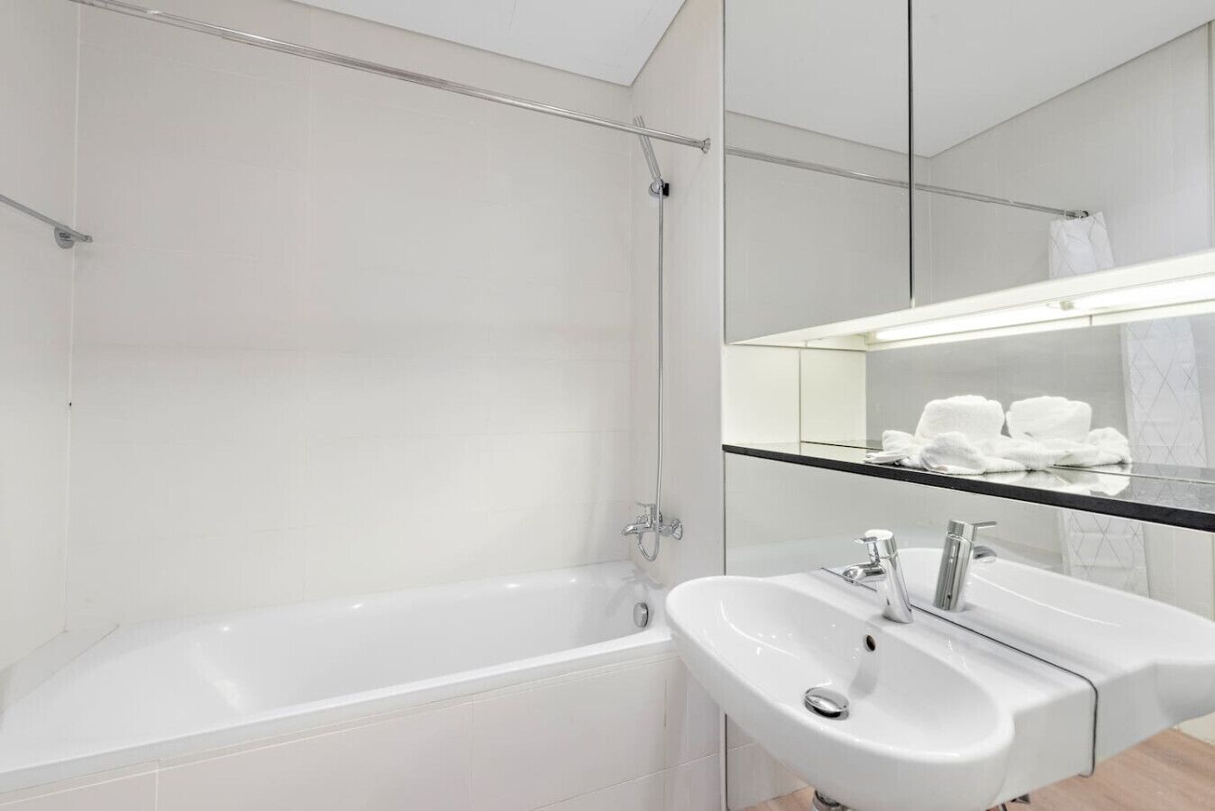 A modern bathroom with a bathtub, a sink, and a mirror.
