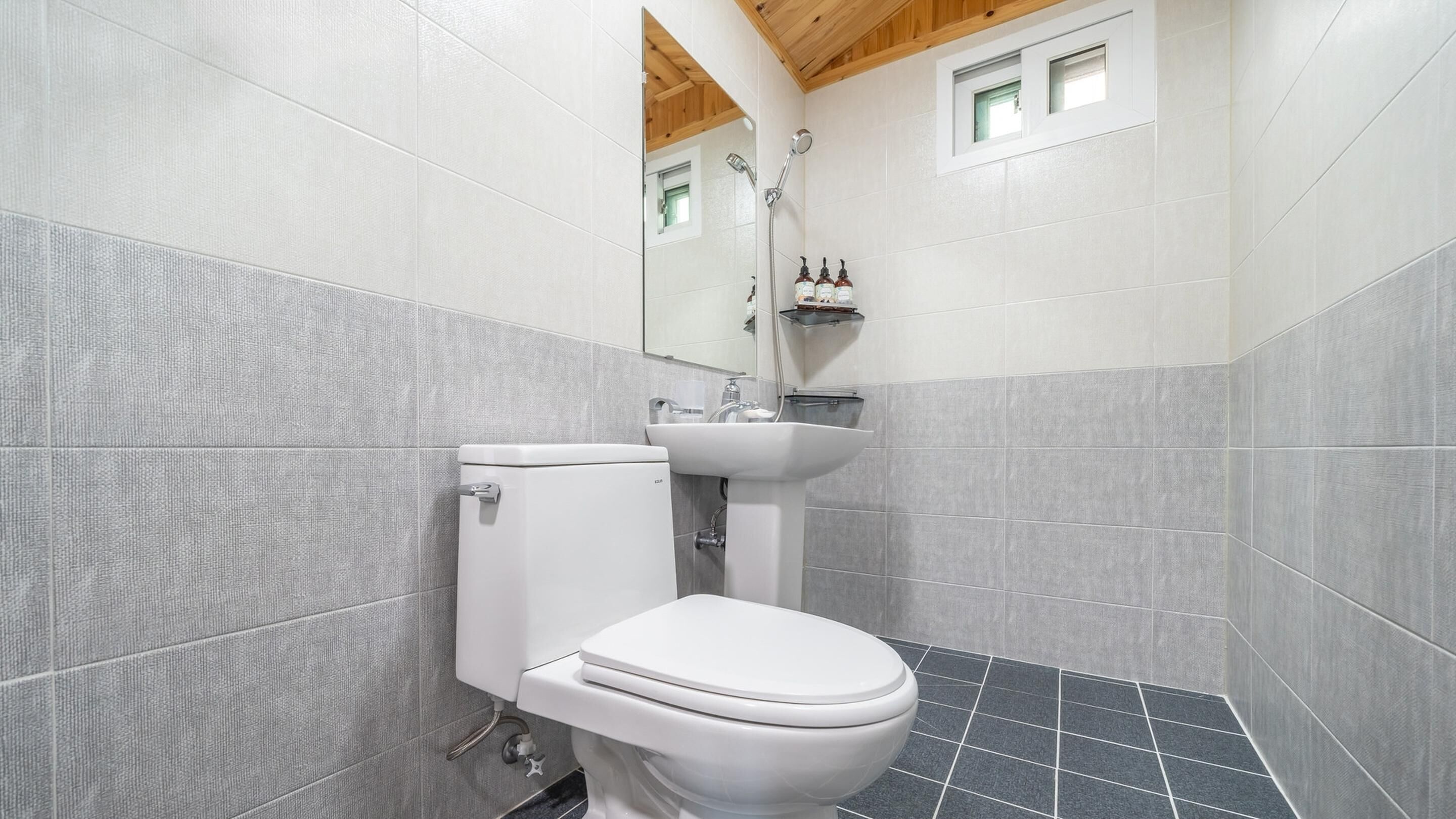 A bathroom with a toilet, sink, and shower.