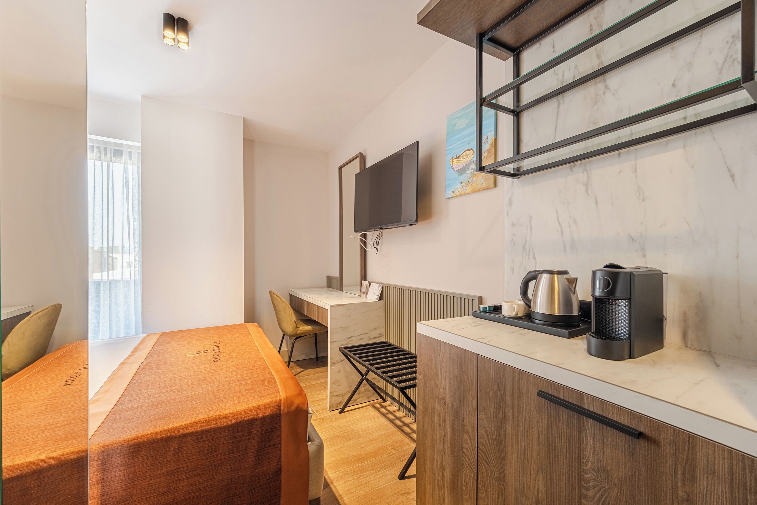A modern kitchen with a wooden dining table, a built-in stove, and a coffee maker.