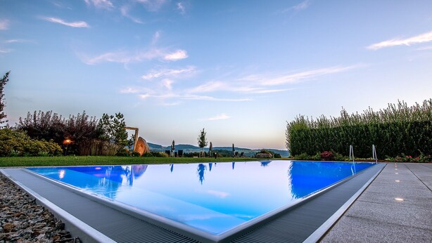 A rectangular infinity pool with a clear blue sky in the background. - Landrefugium Obermüller (Untergriesbach)