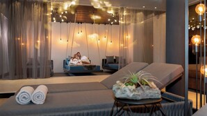 Un spa moderno con una camilla de masaje, un rincón de descanso y una iluminación ambiental.
