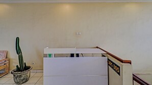 A reception desk with a sign reading "301-305" and a potted cactus to the left. - Hotel O Simalem Guest House (Kuta)