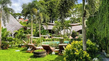 Una piscina al aire libre, sombrillas, tumbonas