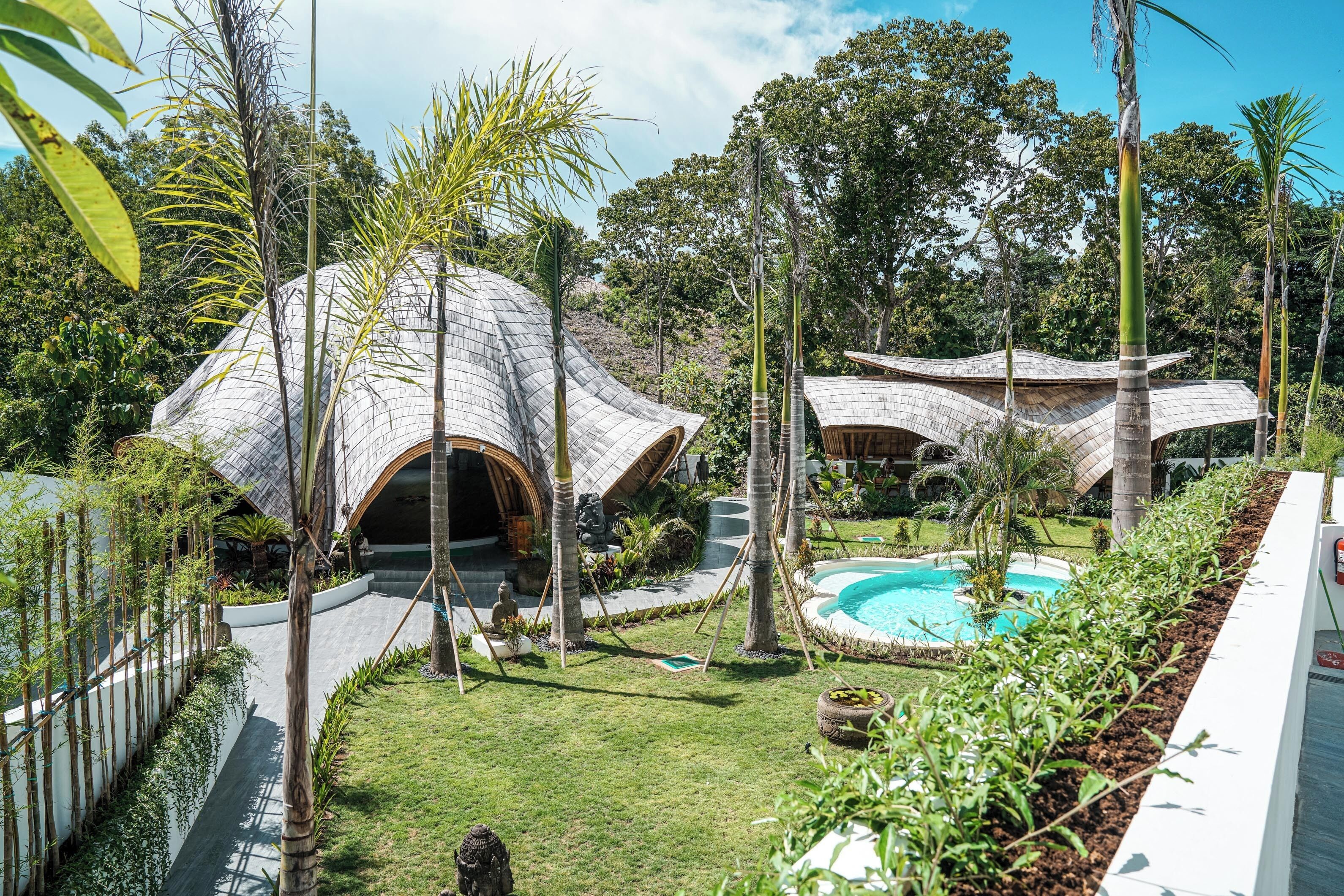 Un resort con estructuras en forma de cúpula únicas, piscina y exuberante vegetación.