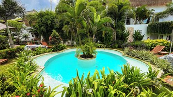 Una piscina al aire libre, sombrillas, tumbonas