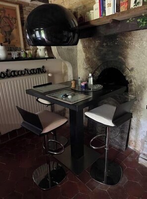Enjoy meals in a warm and inviting dining area with a stone fireplace and comfortable seating.