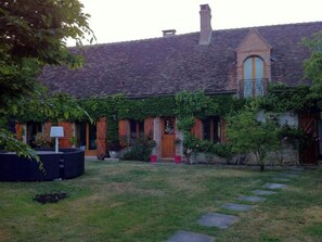 Traditional brick building with an arched window and lush greenery.