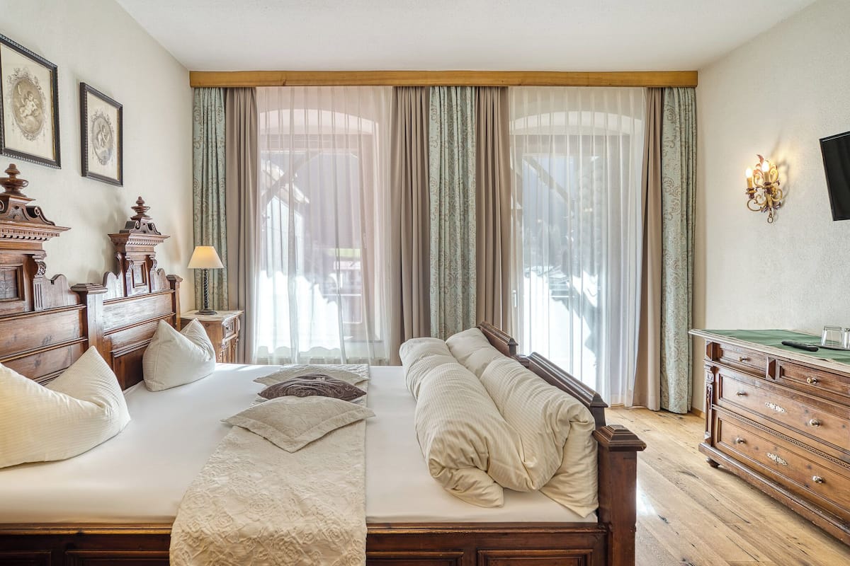 Un dormitorio con una cama grande, cabecera de madera y una cómoda con espejo.