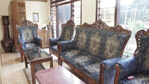 Una habitación tradicional con un conjunto de sofás, una mesa de centro de madera y una lámpara de pie alta.