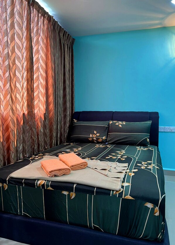 A neatly made bed with a leaf-patterned bedspread, two pillows, and folded towels. - ARK RAWANG BUSINESS HOTEL (Rawang)