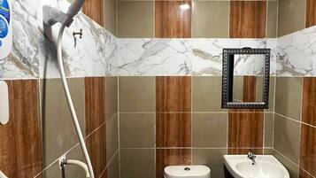 A bathroom with a toilet, sink, and shower.