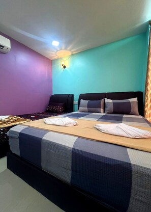 Habitación de hotel con una cama grande, dos almohadas, aire acondicionado de pared y una luz en el techo.