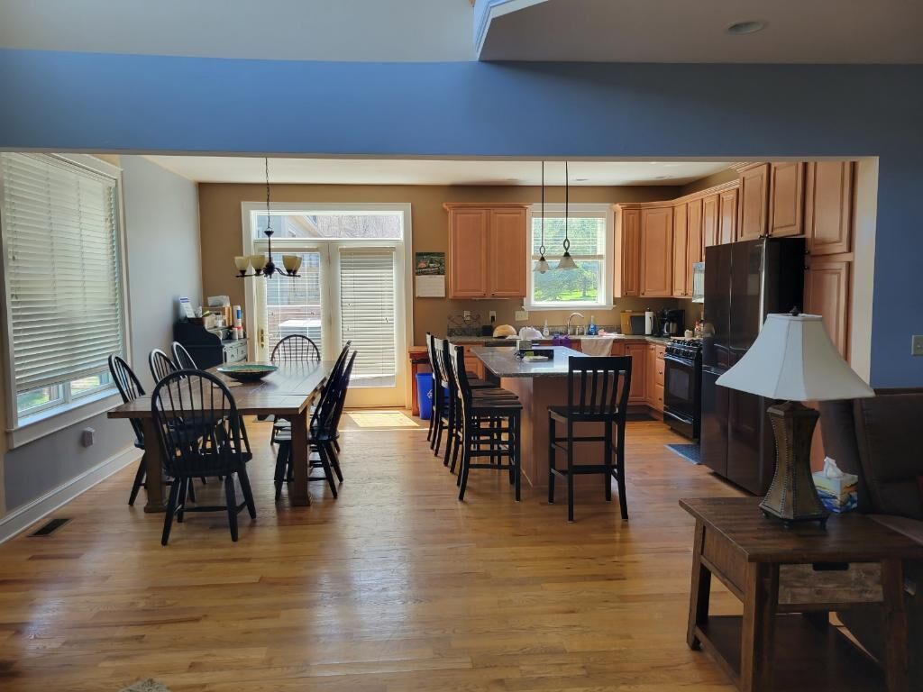 Una cocina amplia con armarios de madera, un comedor con sillas y una isla central.