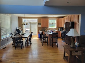 Una cocina amplia con armarios de madera, un comedor con sillas y una isla central.