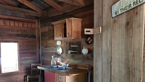 Una cocina rústica con armarios de madera, un lavamanos y un ventanal.