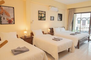 Habitación de hotel con dos camas, un balcón y obras de arte en las paredes.