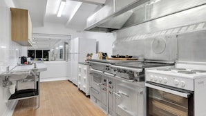 A modern kitchen with stainless steel appliances, a large sink, and a wooden cabinet. - Bulla Homestead  (Bulla)
