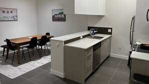 Una cucina moderna con isola centrale, elettrodomestici integrati e zona pranzo con tavolo e sedie.