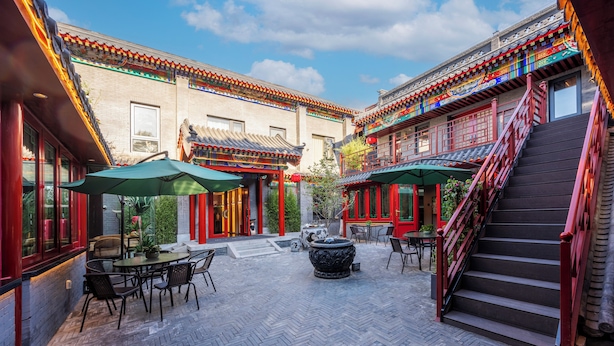 A courtyard with traditional architecture, outdoor seating, and a staircase. - fuxueqiuguojiudian (Beijing)