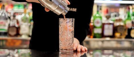 A bartender pouring a drink into a glass.
