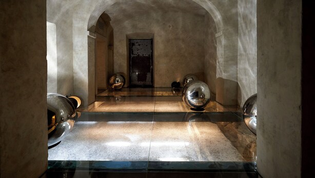 A room with a glass floor, stone walls, and a door in the center. - SUGAR ROOMS Residenza d' Epoca (Arezzo)
