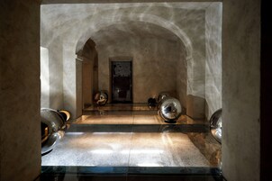 Una habitación con piso de vidrio, paredes de piedra y una puerta en el centro.