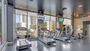 A gym with treadmills and exercise bikes, large windows with city views, and a modern design. - Spectacular Apartment, Balcony View, Amazing Pool (Hallandale Beach)