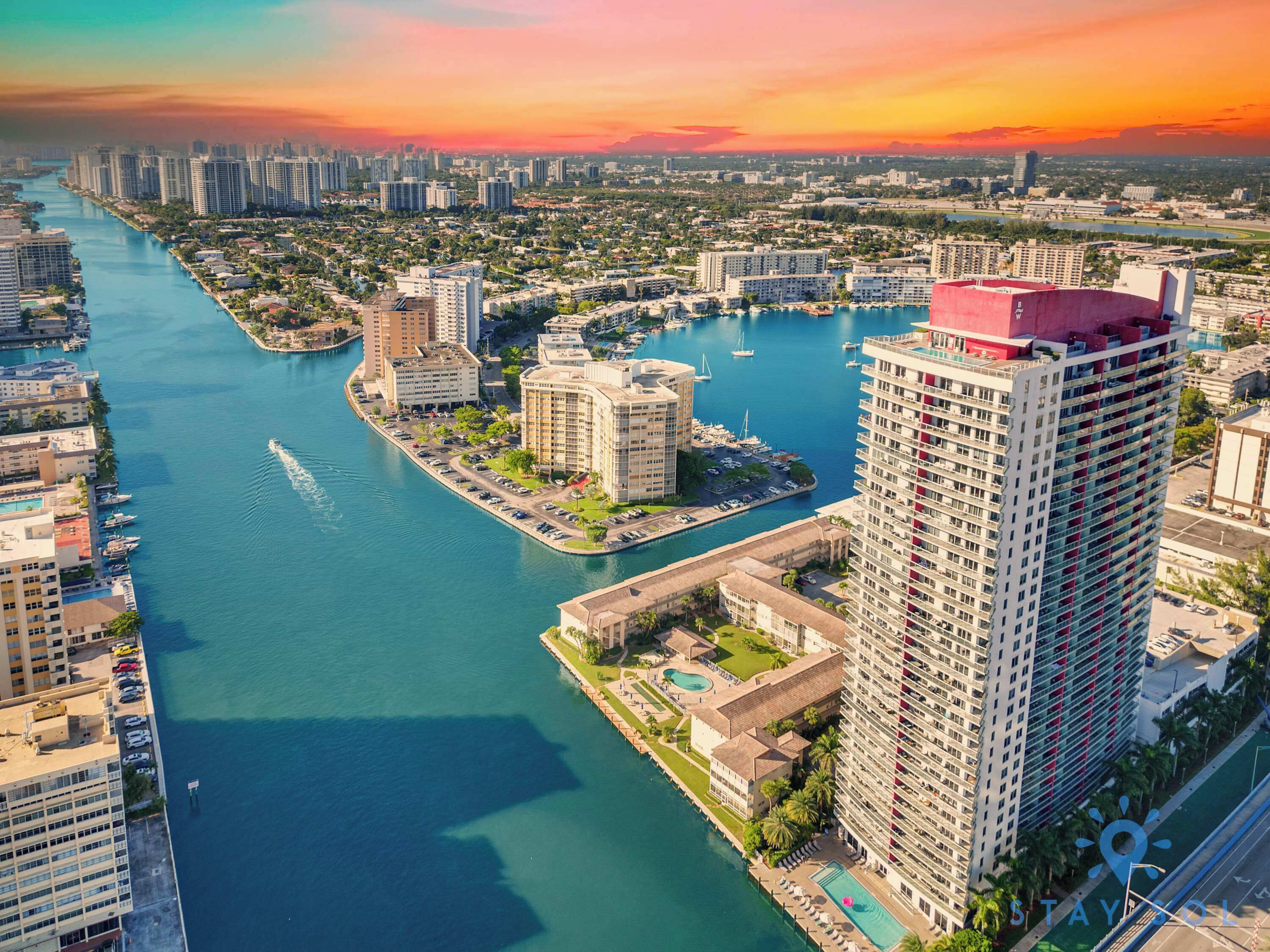 A high-rise hotel with a swimming pool, waterfront views, and a marina.