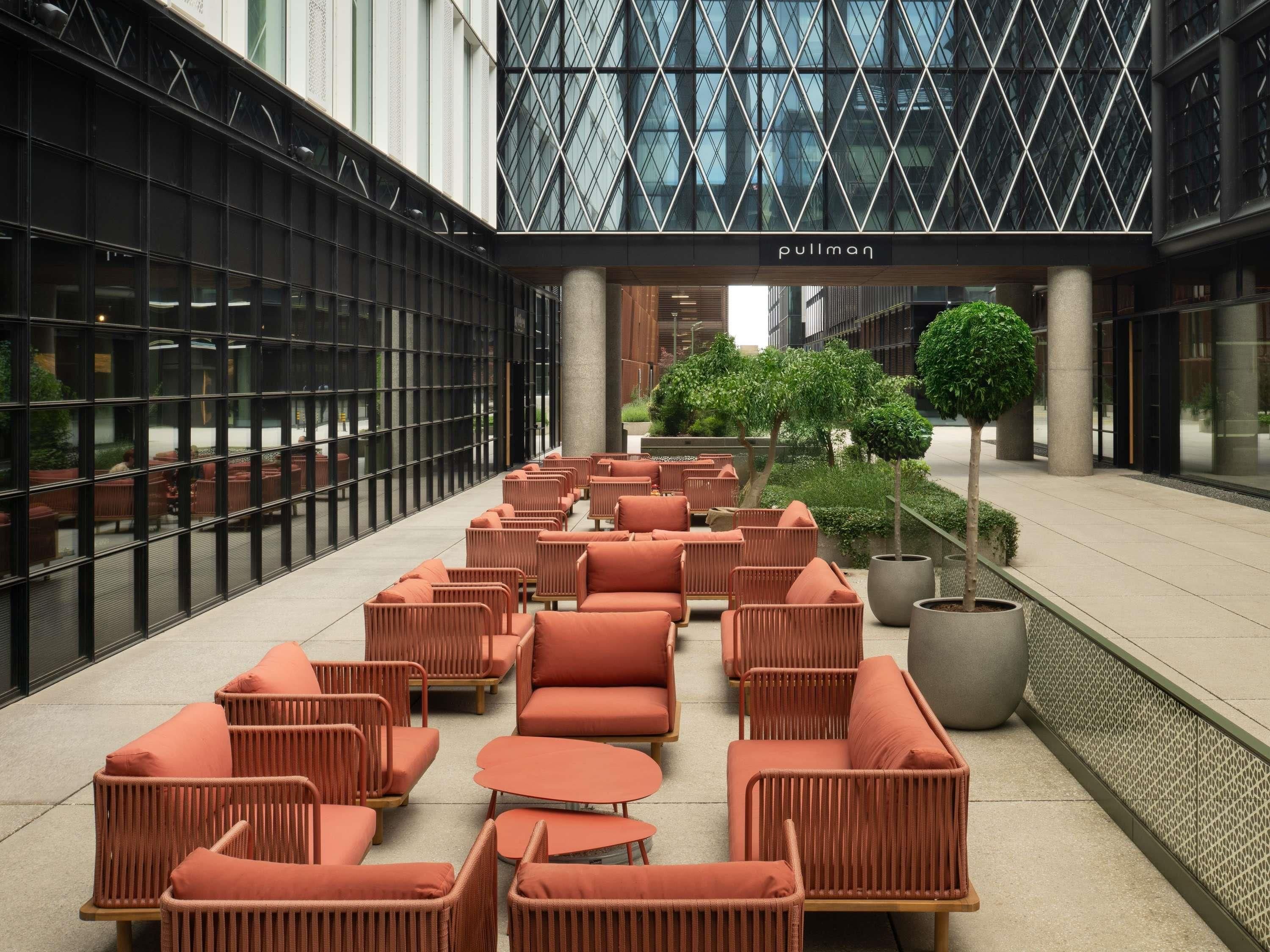 A modern indoor seating area with wicker furniture and a central planter.