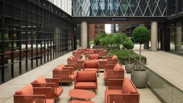 A modern indoor seating area with wicker furniture and a central planter.