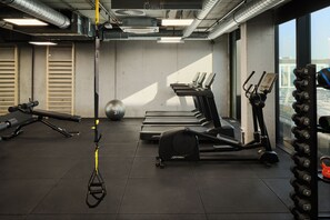 A gym with treadmills, elliptical machines, a stationary bike, a rowing machine, and a set of dumbbells. - Pullman Zagreb (Zagreb)