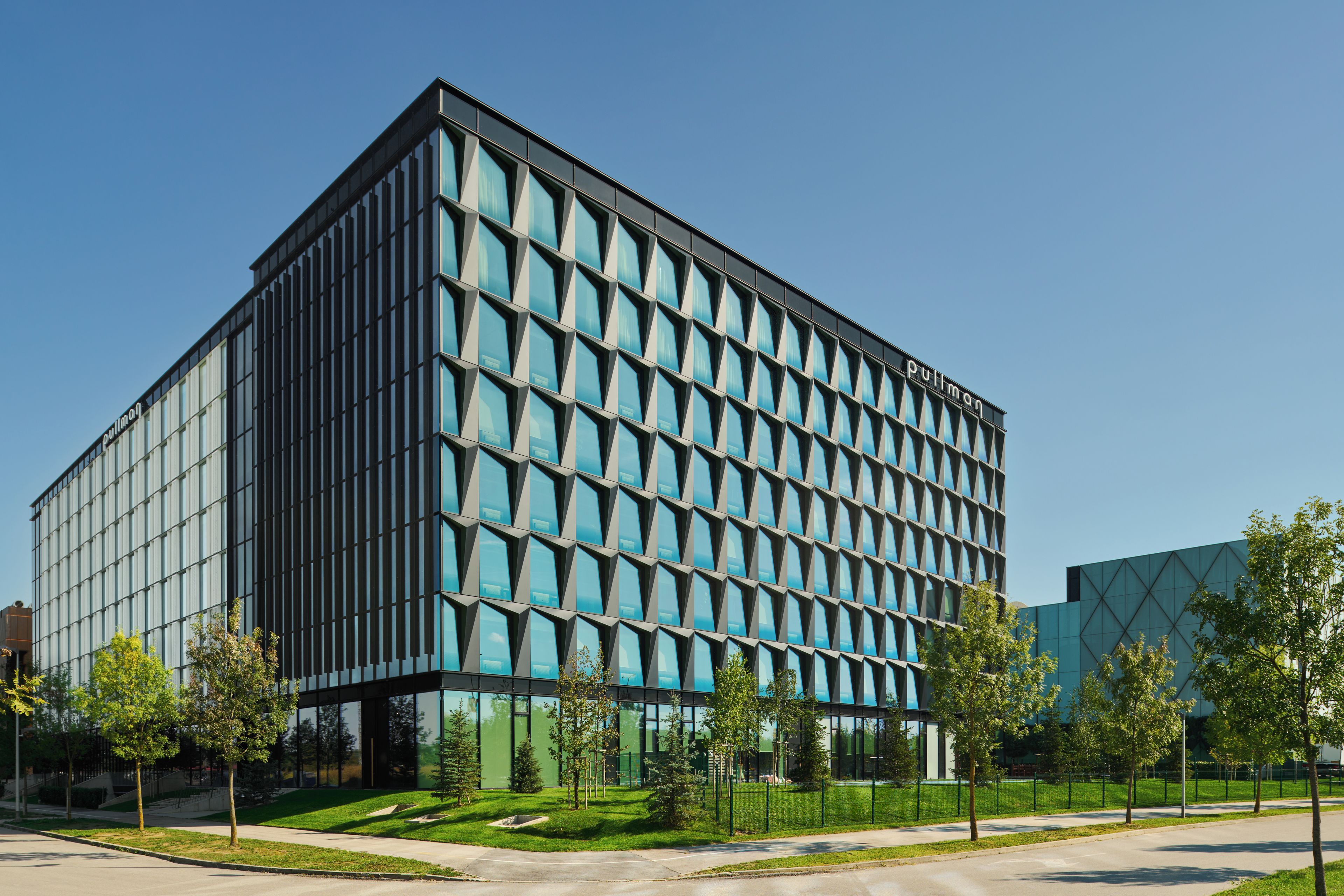 A modern building with a grid of windows and a sign reading "Pullman".