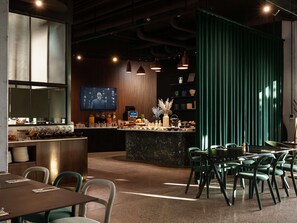 A modern restaurant with a bar area, seating, and a television screen. - Pullman Zagreb (Zagreb)