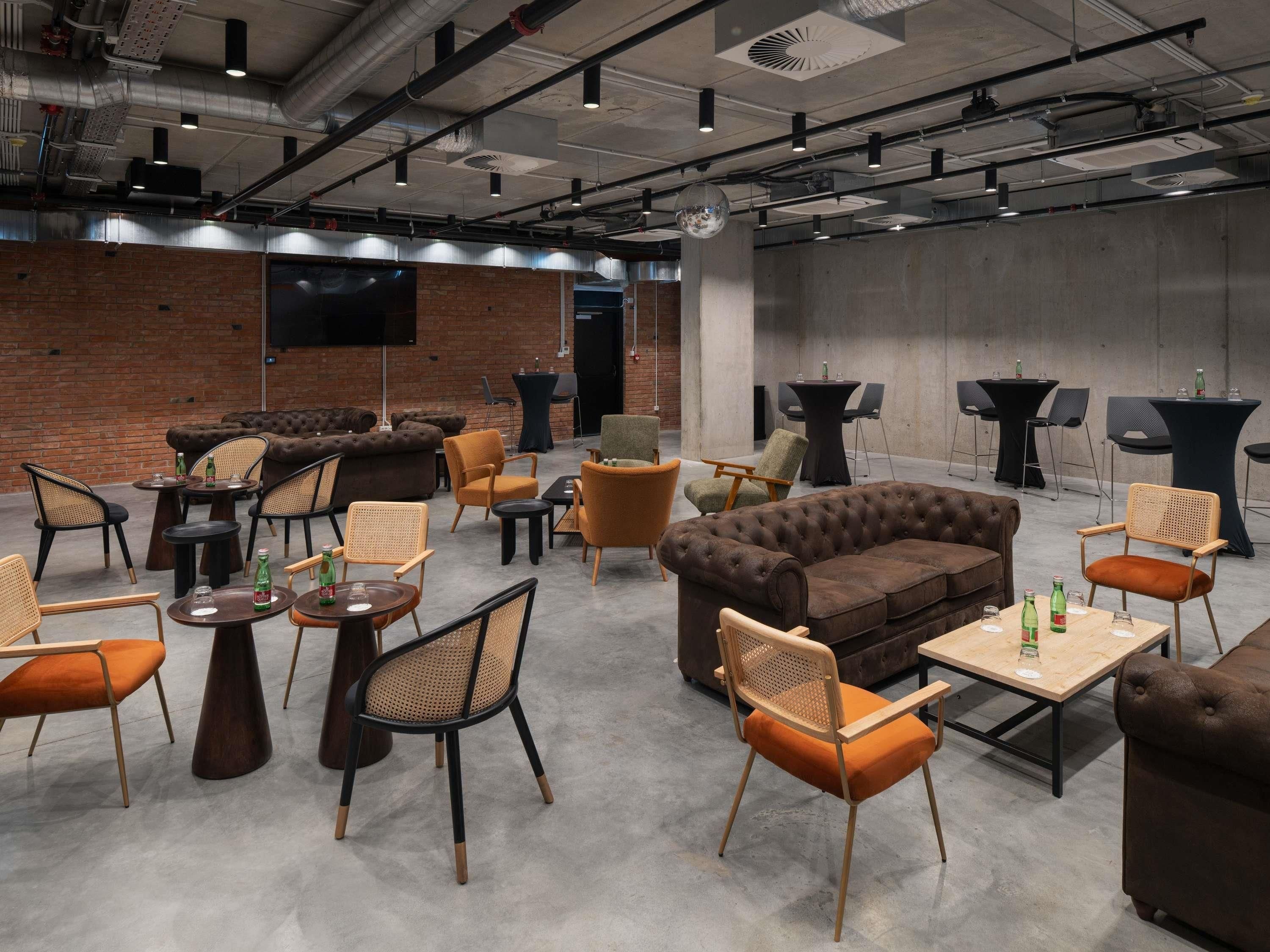 A spacious lounge area with multiple seating options including sofas, chairs, and tables.