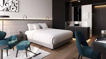 Una habitación de hotel moderna con una cama grande, dos sillones, un escritorio y un minibar.