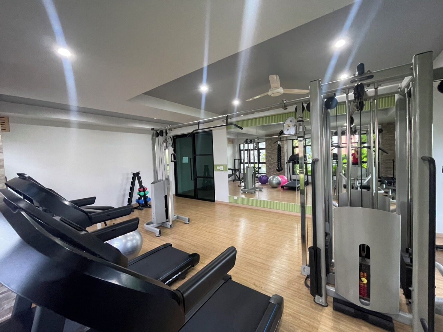 Et fitnesscenter med løbebånd, styrkemaskiner og træningsbolde.