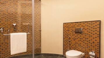 A modern bathroom with a glass shower enclosure, a toilet, and a sink.
