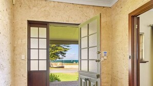 Un pasillo con piso estampado que conduce a una puerta con vistas al exterior.