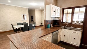 Una cocina moderna con una isla grande, armarios blancos y una ventana con plantas.