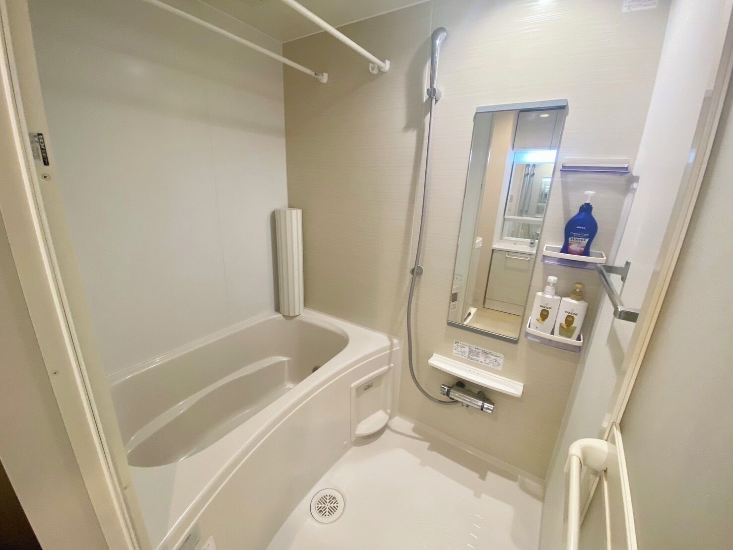 Een badkamer met een bad, douche, toilet en spiegel.