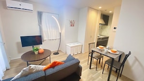 Ein gemütlicher Wohnbereich mit einer Couch, einem Esstisch und einem Fernseher.