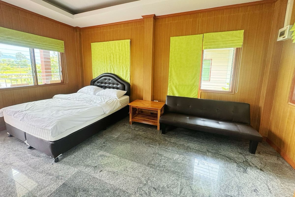 A bedroom with a bed, a bench, and a small table.