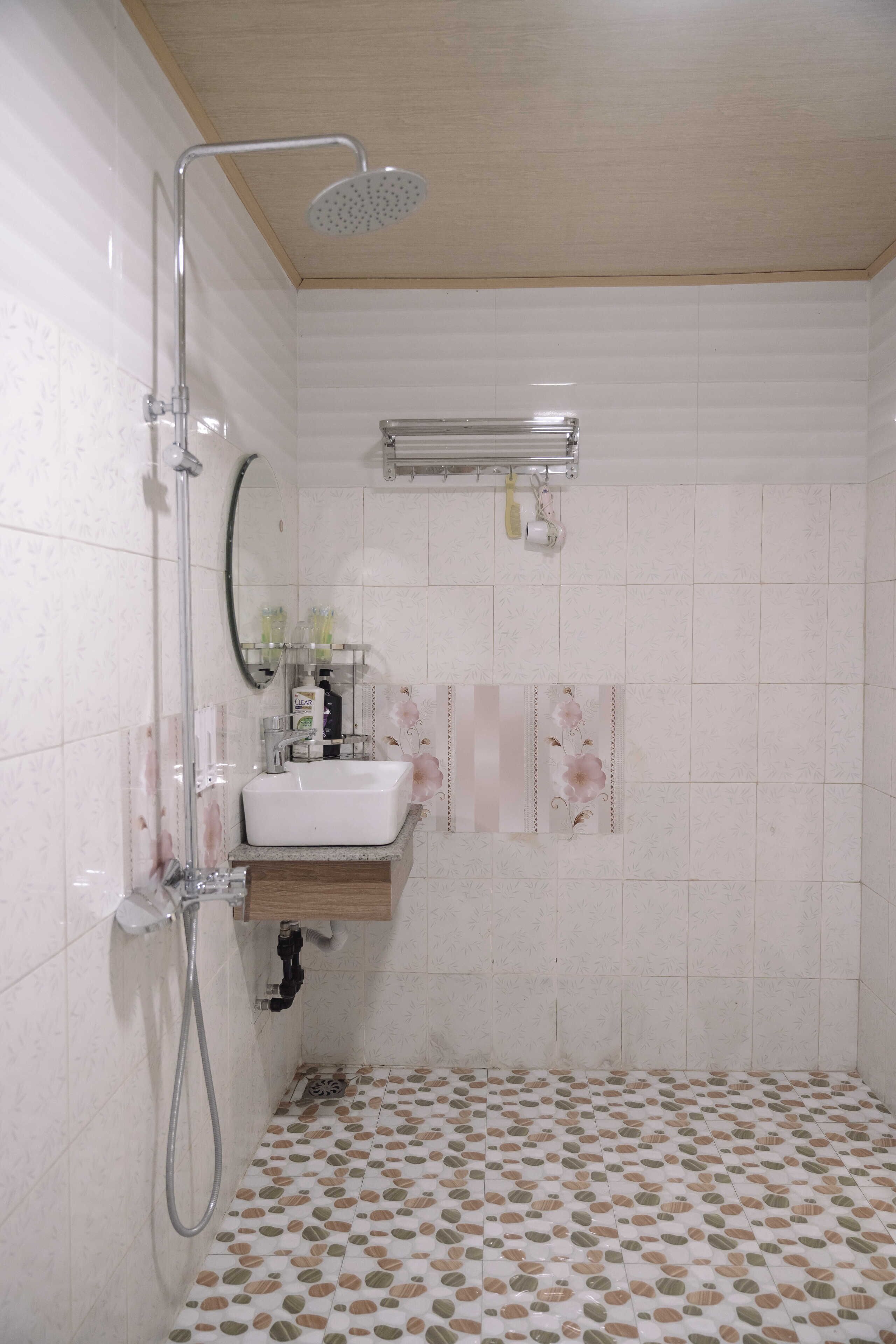Un bagno con doccia, lavandino e specchio.