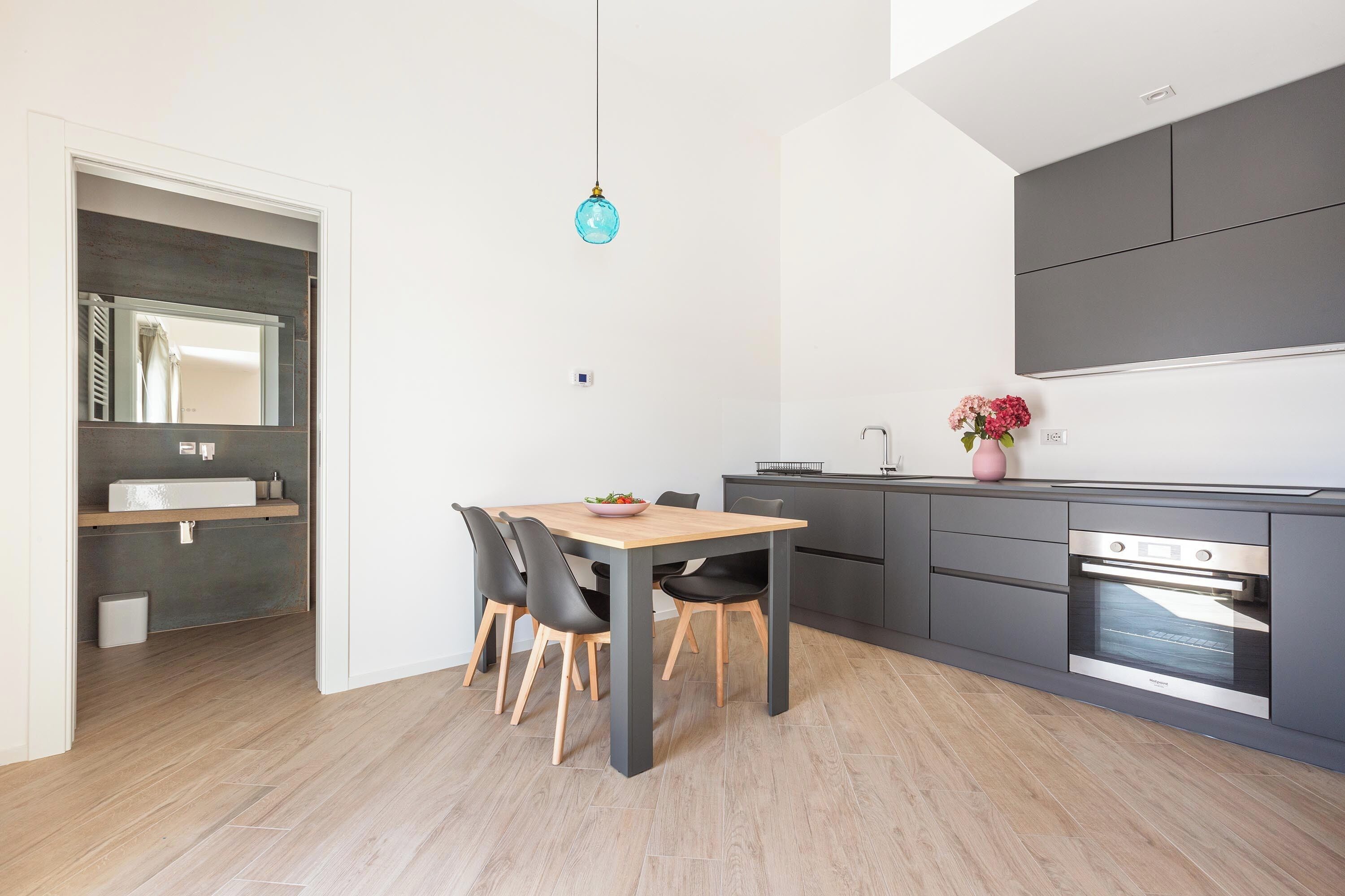 Une cuisine moderne avec un coin repas, des appareils électroménagers intégrés et un design minimaliste.