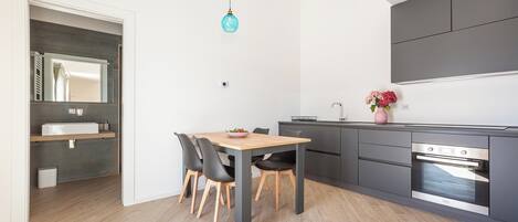 Une cuisine moderne avec un coin repas, des appareils électroménagers intégrés et un design minimaliste.