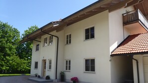 Un edificio a due piani con tetto in tegole, diverse finestre e un balcone.