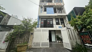 Un edificio de dos pisos con un letrero que dice "Nhà Nghỉ Kim Chi".
